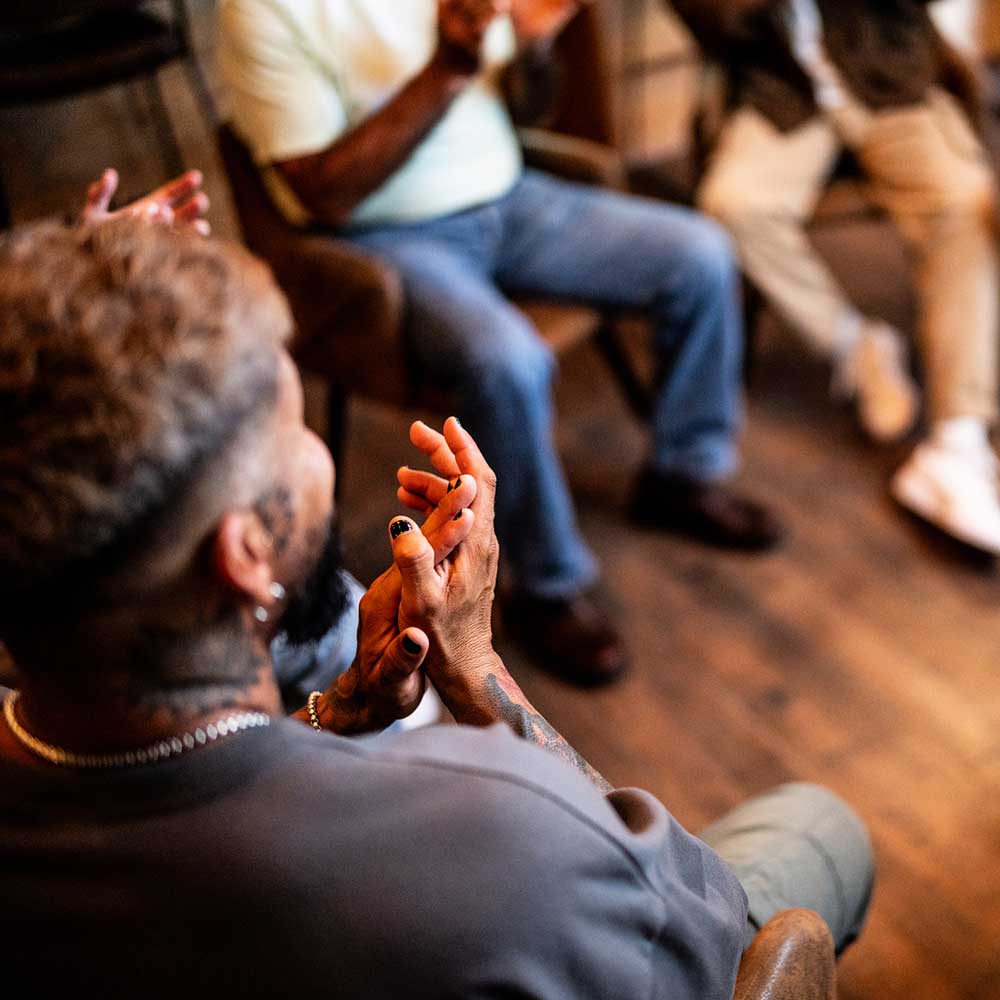 Men applauding in group therapy at mental health center