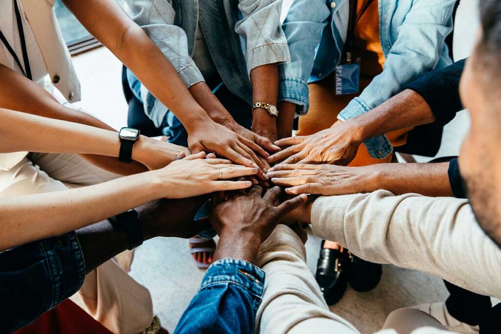 Diverse hands joining together, symbolizing unity, cooperation, and collaboration